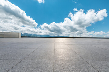 Empty square floor and mountains under blue sky