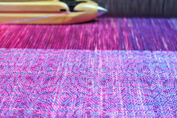 Fototapeta premium Multicolored texture textile in a wooden loom machine.