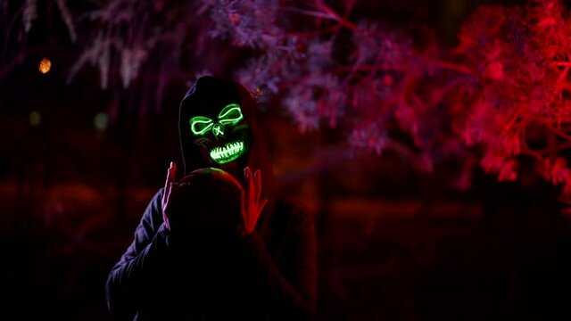 celebration of all hallows Eve, person in suit of death or ghost with glowing skull, holding pumpkin
