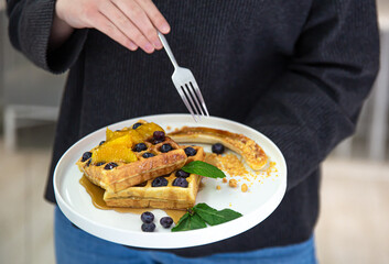 Close-up of Belgian waffles with berries and fruits.