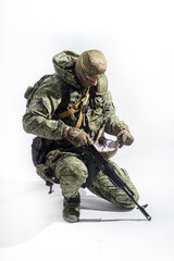 Members of the special purpose unit. A Russian special forces soldier with assault rifle aiming from a machine gun on a white background