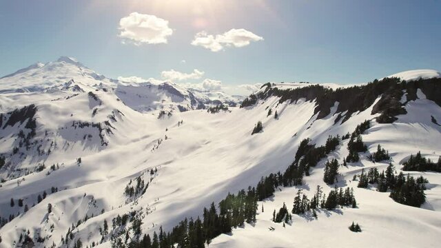 Snowy Mountain Wilderness Aerial with Spring Sun on Mount Baker Peak
