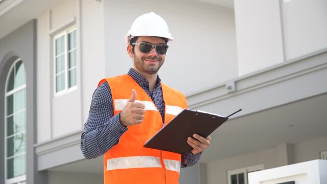 architect  holding clipboard  checking list and audit on construction site at village show thumps up and looking camera . foreman worker Inspection home