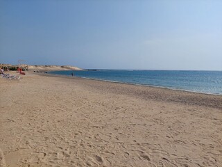 Fototapeta na wymiar Beautiful bay in Marsa Alam, Egypt. Sandy beach and crystal clear sea. Walking along the beach.
