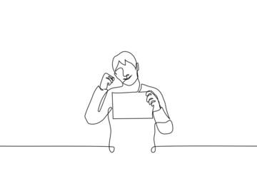 man smiling showing horizontal blank poster or sheet of paper and clenched fist encouraging gesture - one line drawing vector. the concept of 