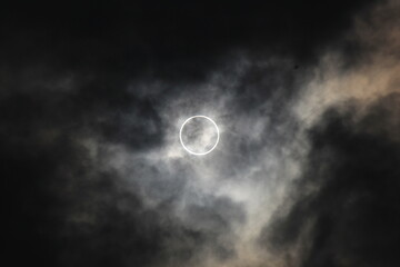 Naklejka na ściany i meble Solar Eclipse on a cloudy day taken in Japan. The clouds give it a very dramatic effect.