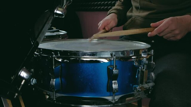 close up - the drummer plays with sticks on a snare drum, home lesson paradiddle training