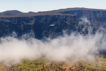 Flug über eine SChlucht und Wolken auf Reunion