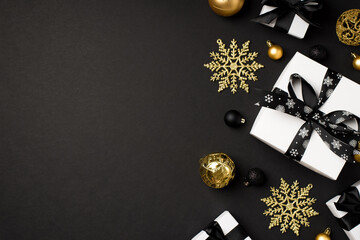 Top view photo of christmas decorations gold and black balls snowflakes and white gift boxes with...