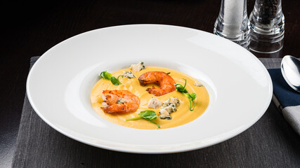 Autumn food pumpkin soup with shrimps. Served for dinner