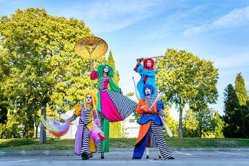 Excited clowns performing various tricks during festive event in park