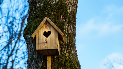 A bird house with a heart-shaped entrance.
