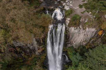 Aerial flying drone bird's eye view Beautiful long exposure landscape early Autumn image of Pistyll Rhaeader waterfall in Wales