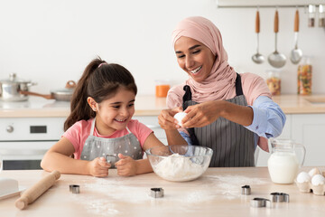 Obraz na płótnie Canvas Cheerful Muslim Family Mother And Little Daughter Cooking In Kitchen Together