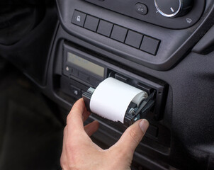 Digital tachograph with an open printer and visible roll of paper. Paper roll Replacement in a...
