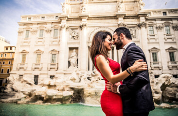 Couple kissing in Rome at the famous Trevi fountain