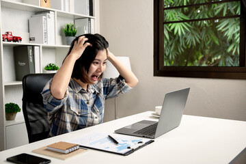 Young business woman stressed from work in home office.
