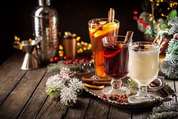 fresh yellow eggnog, grog and fruity red mulled wine with Christmas decoration. Selection of autumn...