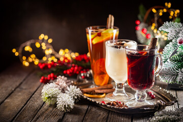 fresh yellow eggnog, grog and fruity red mulled wine with Christmas decoration. Selection of autumn or winter alcoholic hot drinks