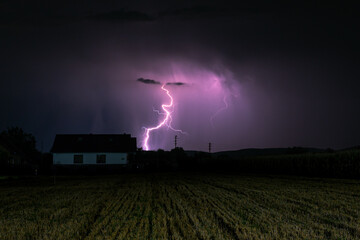 Lightning strikes behind a house in the countryside of Transylvania, Romania
