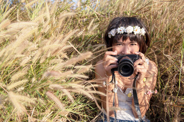 Fototapeta premium Portrait of a sensual Young photographer girl taking photos outdoor with wearing flowers crown
