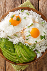 Arroz con huevo or rice with fried egg is the ultimate Latin lazy lunch close up in the plate on the table. Vertical top view from above