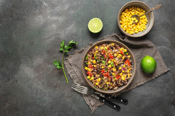 Salad with black beans, corn and quinoa in a bowl on a dark grunge background. Mexican food. Top view, flat lay