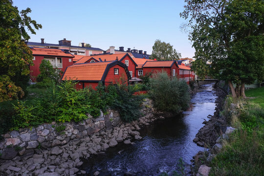 Traditional Swedish red wooden houses on the bank of the river in a small old town Vasteras. Shot before sunset