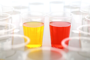 色の付いた水が入った瓶やコップ