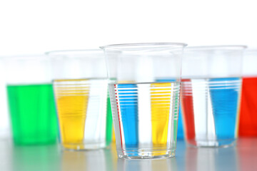 色の付いた水が入った瓶やコップ