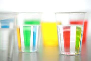 色の付いた水が入った瓶やコップ