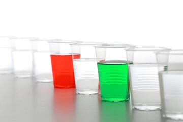 色の付いた水が入った瓶やコップ