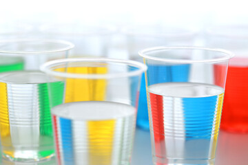 色の付いた水が入った瓶やコップ