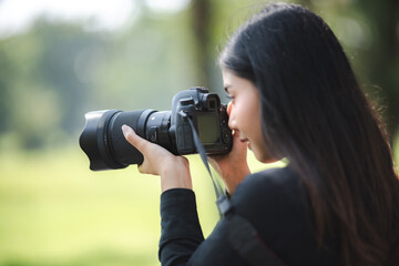 young Asian photographer woman with hight technology digital camera shooting shot