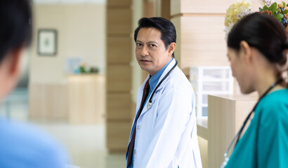 Obraz premium Group of asian doctors team working in hospital. Mixed race professional medical doctor and nurse meeting.