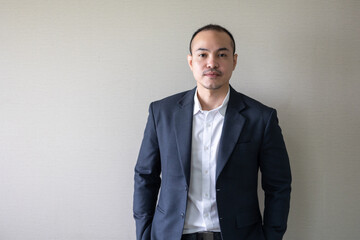 Portrait Asian business man standing look at camera  in modern office. Close up face of businessman smiling
