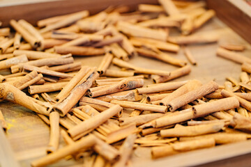 cinnamon sticks on a wooden tray. spice from the bark of an tree in India. 