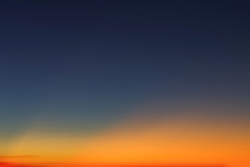 Heaven at early morning with copy space. Sunset, sunrise backdrop.Predawn clear sky with orange horizon and blue atmosphere. Smooth orange blue gradient of dawn sky.