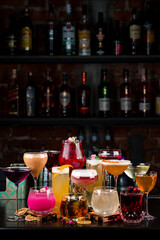 set cocktails on the bar counter against the background of a dark bar vertically - 470417381