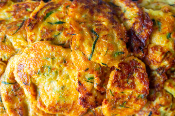 Close-up of pancakes made of zucchini and vegetables. A delicious vegetarian dish. Top view, flat lay, food background