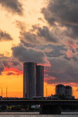 Fototapeta premium Magnificent sunset over the Daugava river in Riga, Latvia with Z towers and the Stone bridge in the background. Colorful clouds and warm skylight