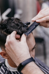 Barber hands cut hair with scissors, close-up