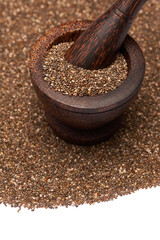 Wooden mortar full of organic natural chia seeds and pestel close-up