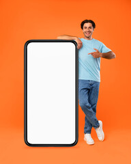 Guy pointing and leaning on big white empty smartphone screen