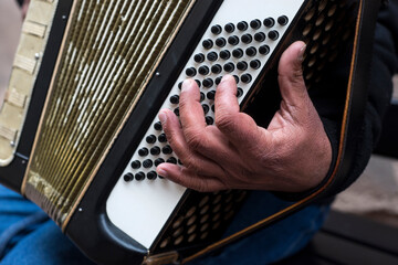Closeup of man of man playing accordion in the street - obrazy, fototapety, plakaty