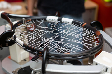 Process of stringing a tennis racket in a tennis shop, new tennis racket string, sport and leisure...