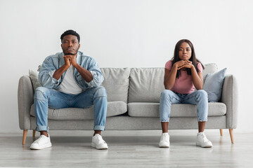 Young married black couple ignoring each other after having fight