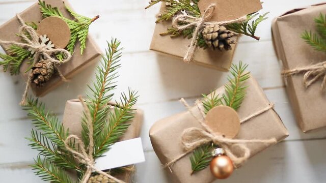 Rotate gift box for Christmas and new year in eco-friendly materials: kraft paper, live fir branches, cones, twine. Tags with mock up, natural decor, hand made, DIY. Flatly, background, Minimalism