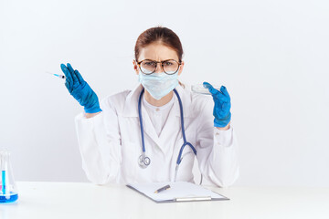 female doctor sitting at the table with blue gloves medication tests