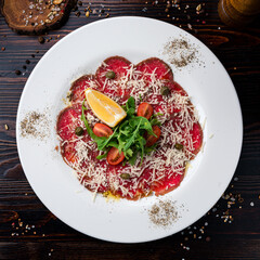 beef carpaccio with salad and lemon top view, flat lay